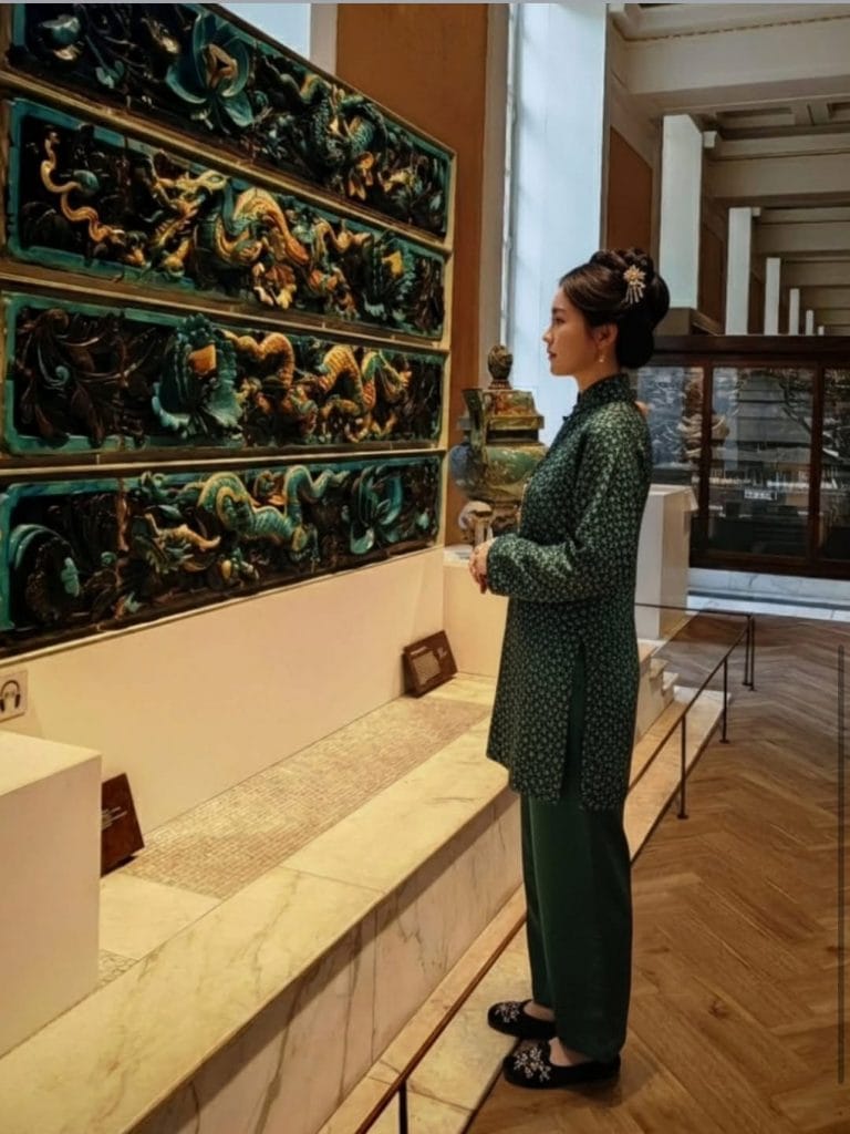 an AI-generated image in which a woman is seen standing in profile in a museum setting contemplating an artifact