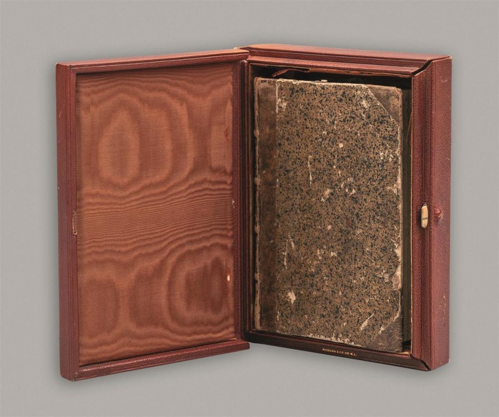 a book in its box on a grey background