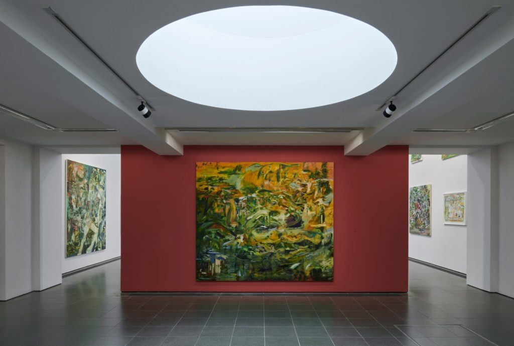 very large, colourful abstract paintings are hanging in a gallery space, it is partially lit with natural light