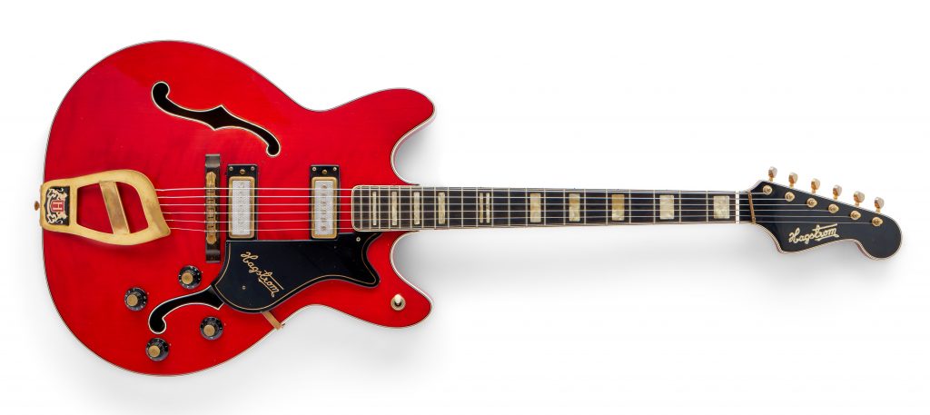Bright red vintage electric guitar with gold hardware and double cutaway body, isolated background