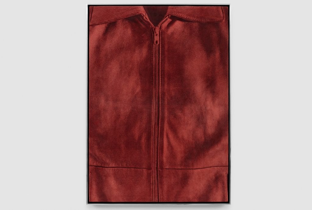 a framed still-life image of the front of a zipped up jacket that is tinted red