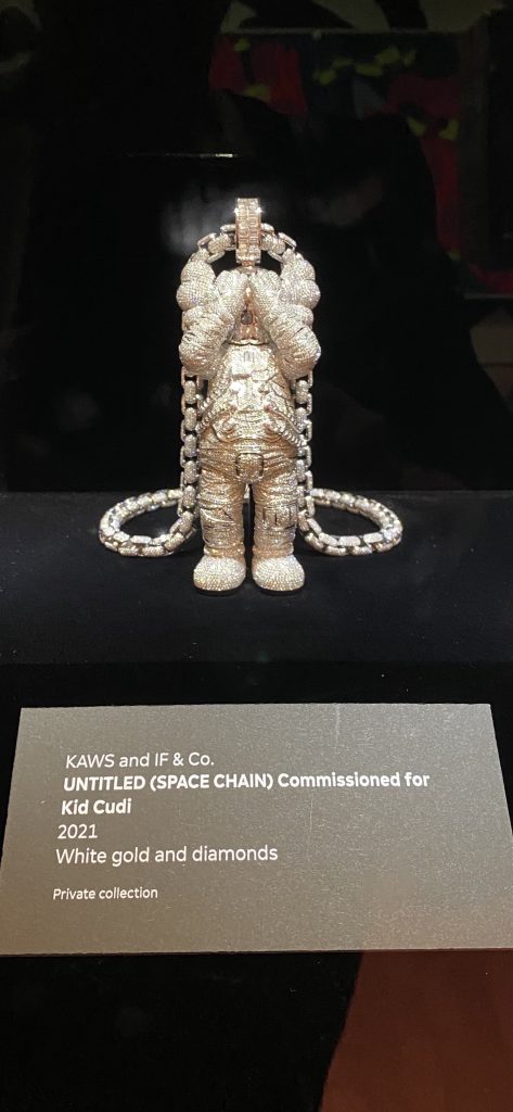 an image of a diamond-encrusted KAWS companion figure covering its eyes