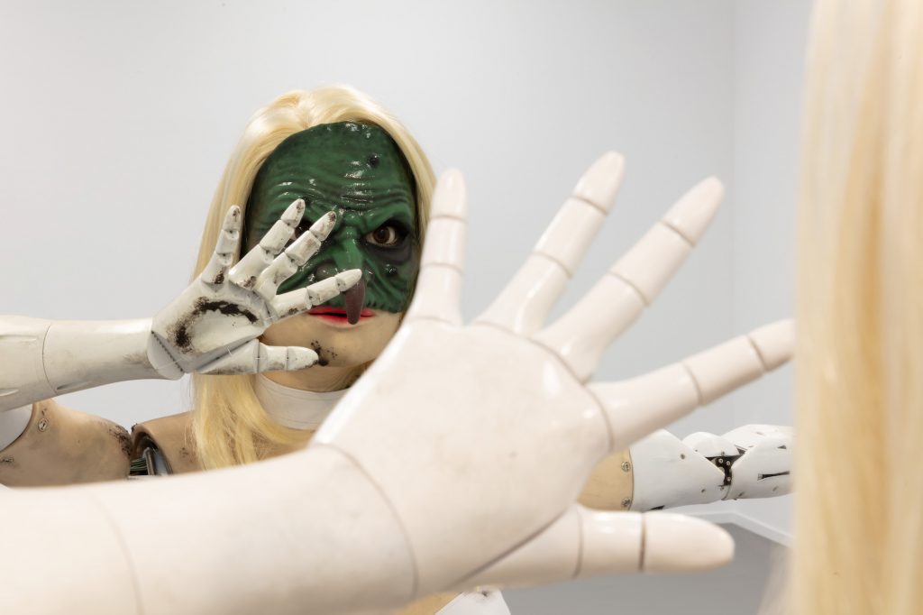 an image of Jordan Wolfson's Female Figure with a green mask and a hand across her face