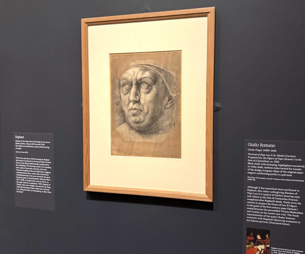 Giulio Romano’s chalk portrait fragment of Pope Leo X hangs in a light wood frame on a dark wall between two descriptive museum labels.