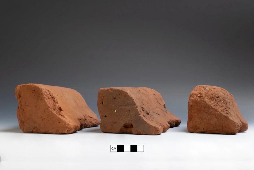 A photograph of three curved bricks prictured atop a white surface against a gray background