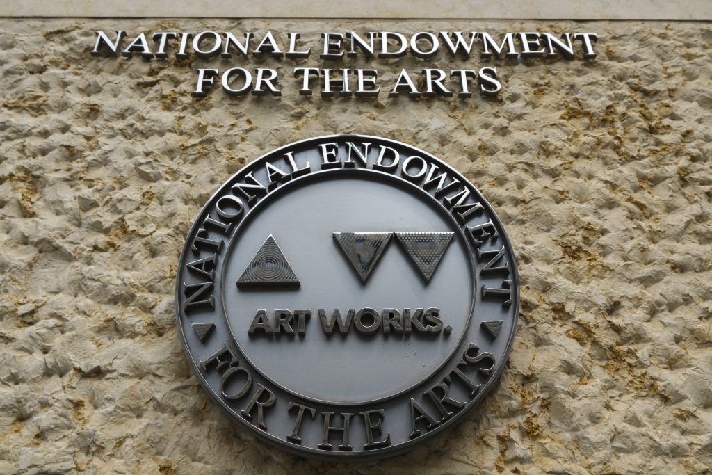 National Endowment for the Arts circular metal seal mounted on textured stone exterior wall surface