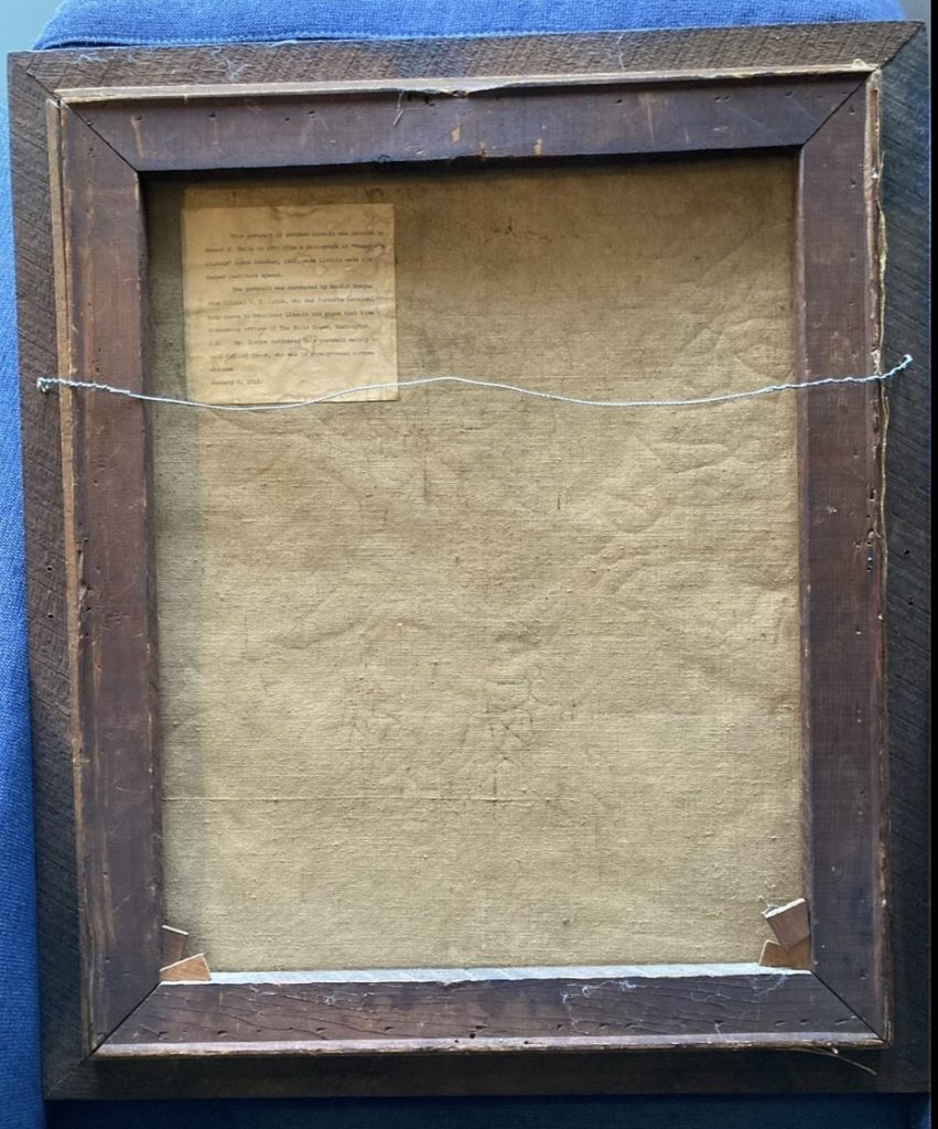 A photograph of the back of the painting that once belonged to Roosevelt, with a letter affixed to its upper left hand corner