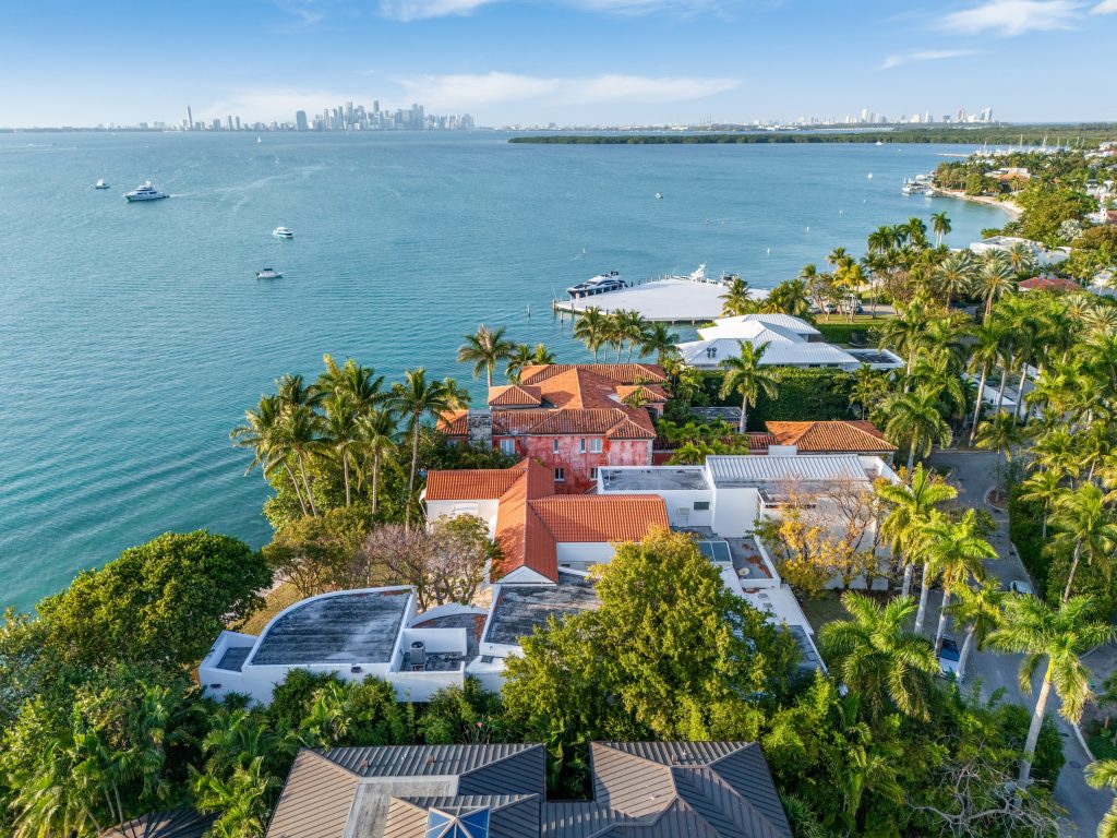 An aerial photo of a mansion owned by Rosa de la Cruz on the waterfront in Miami, with the city skyline in the distance