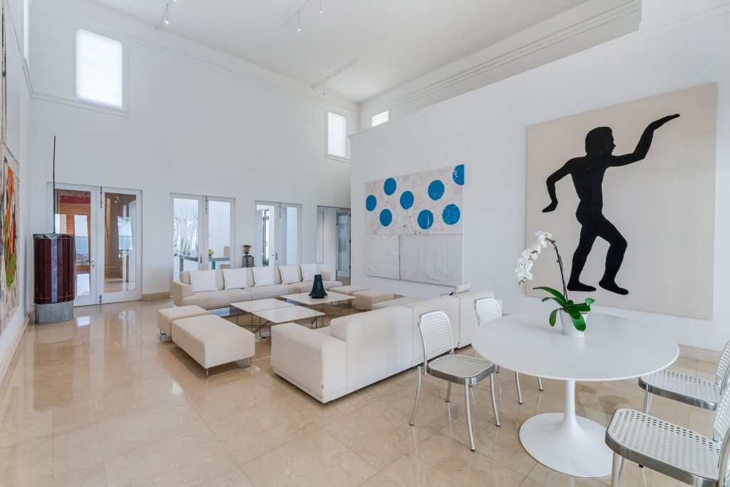 A sunny mansion living area with artworks on the walls