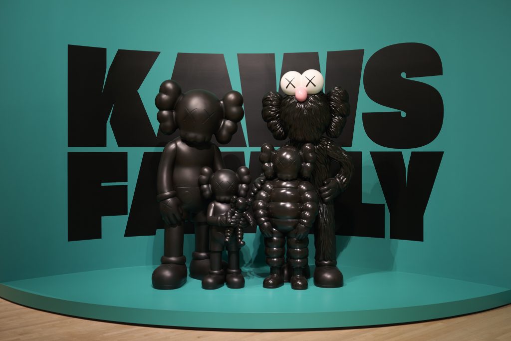 an image of a family of all black figured against a turquoise background