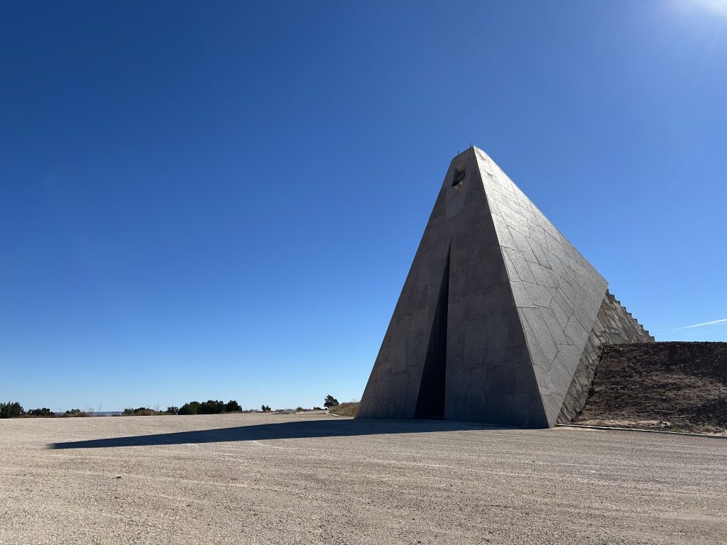 A view of a pyramid shaped structure in the middle of a desert