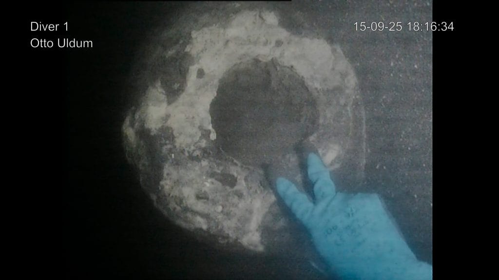 a screen shot from the camera of an underwater diver finding a cannon