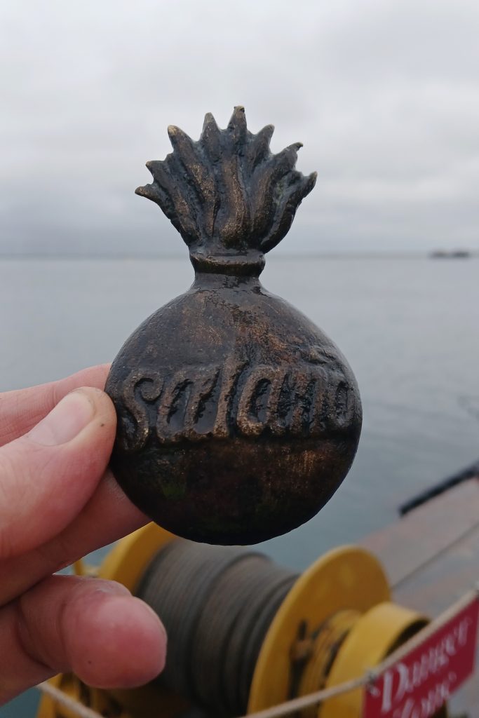 a hand holding an old metal badge