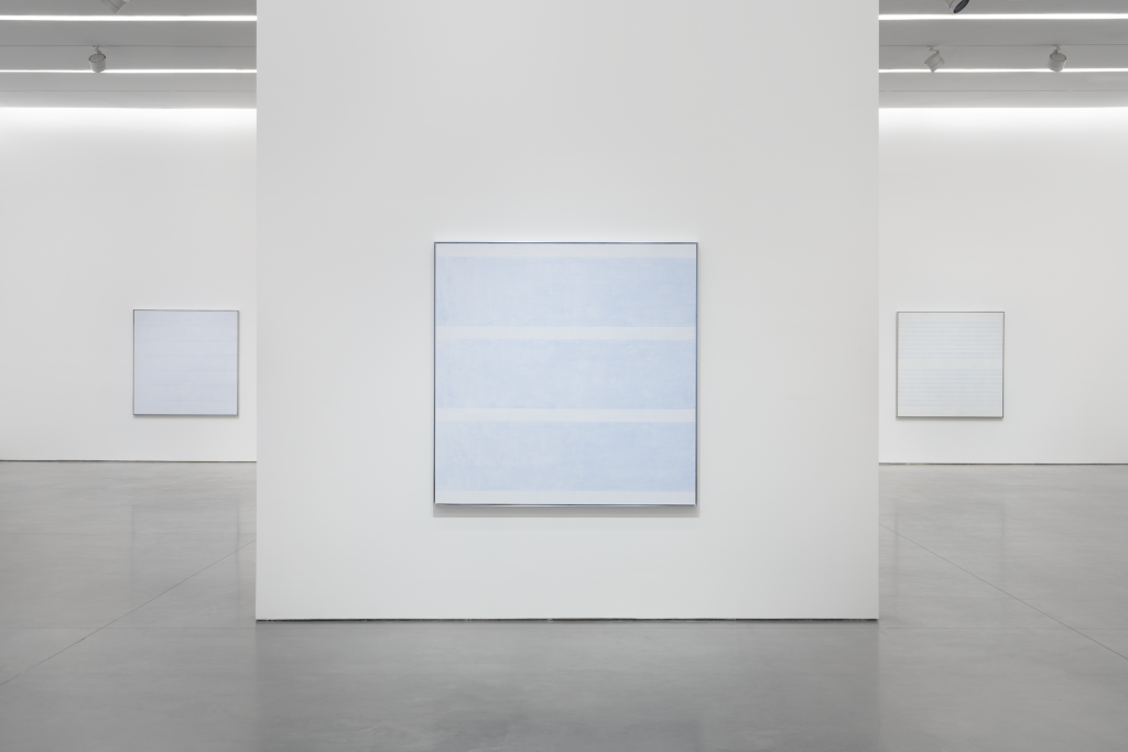 An installation view of subtle white paintings by anges martin in a white cube gallery space